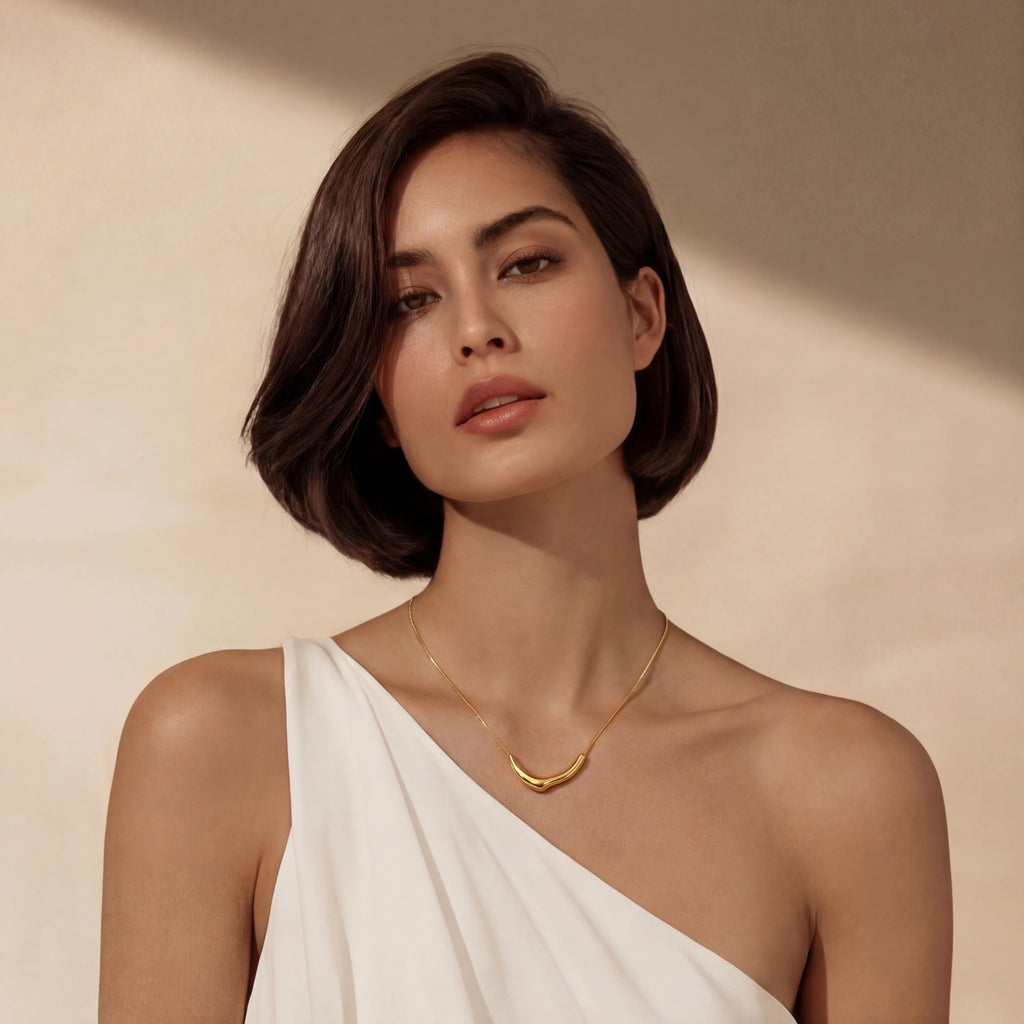 Woman wearing a gold necklace against a beige background