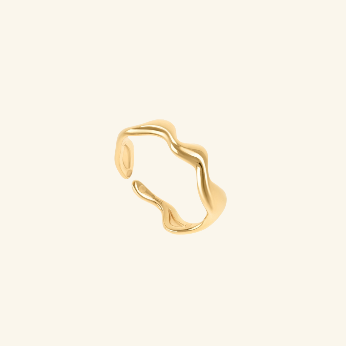 Gold ring with wavy design on a beige background