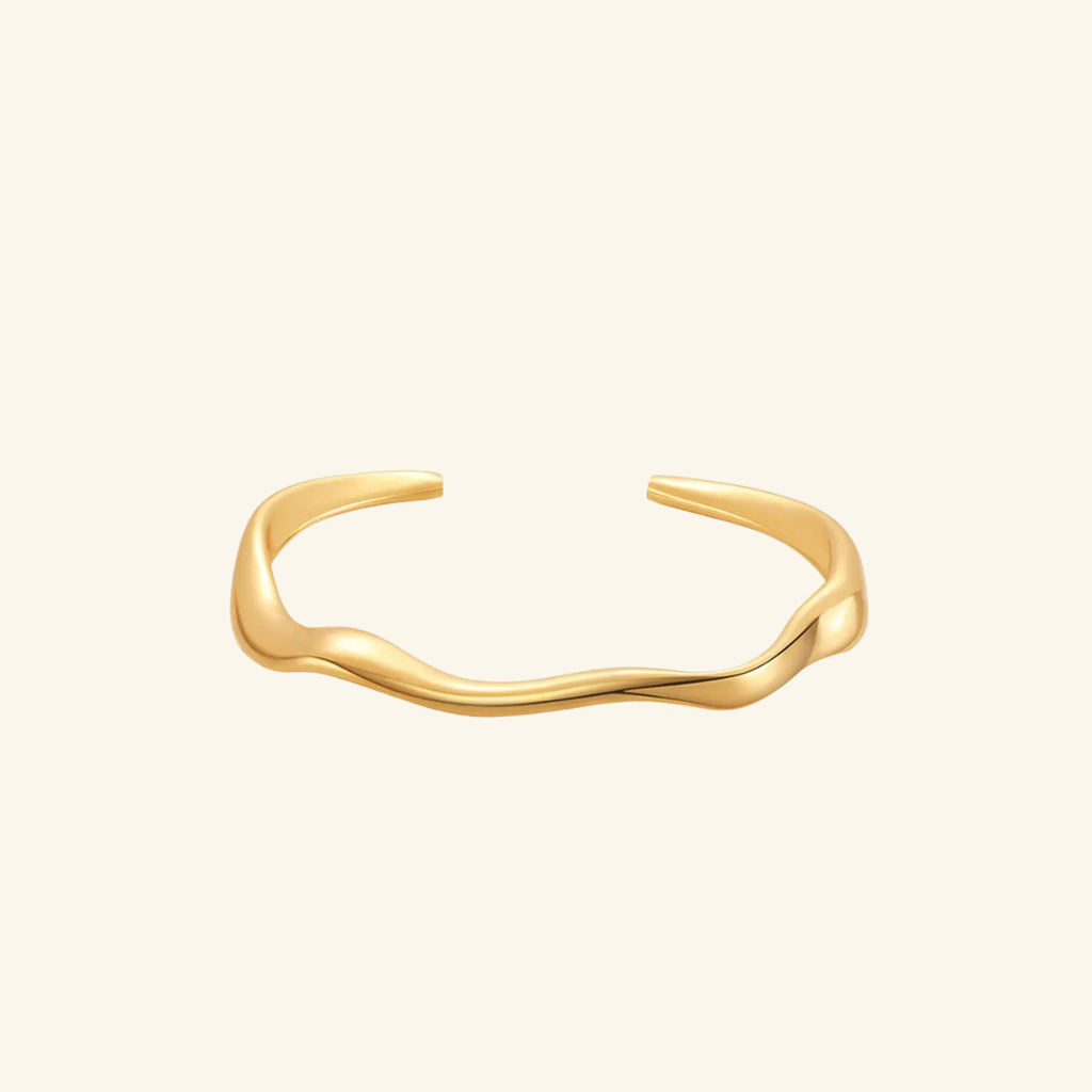 Gold bracelet on a light beige background