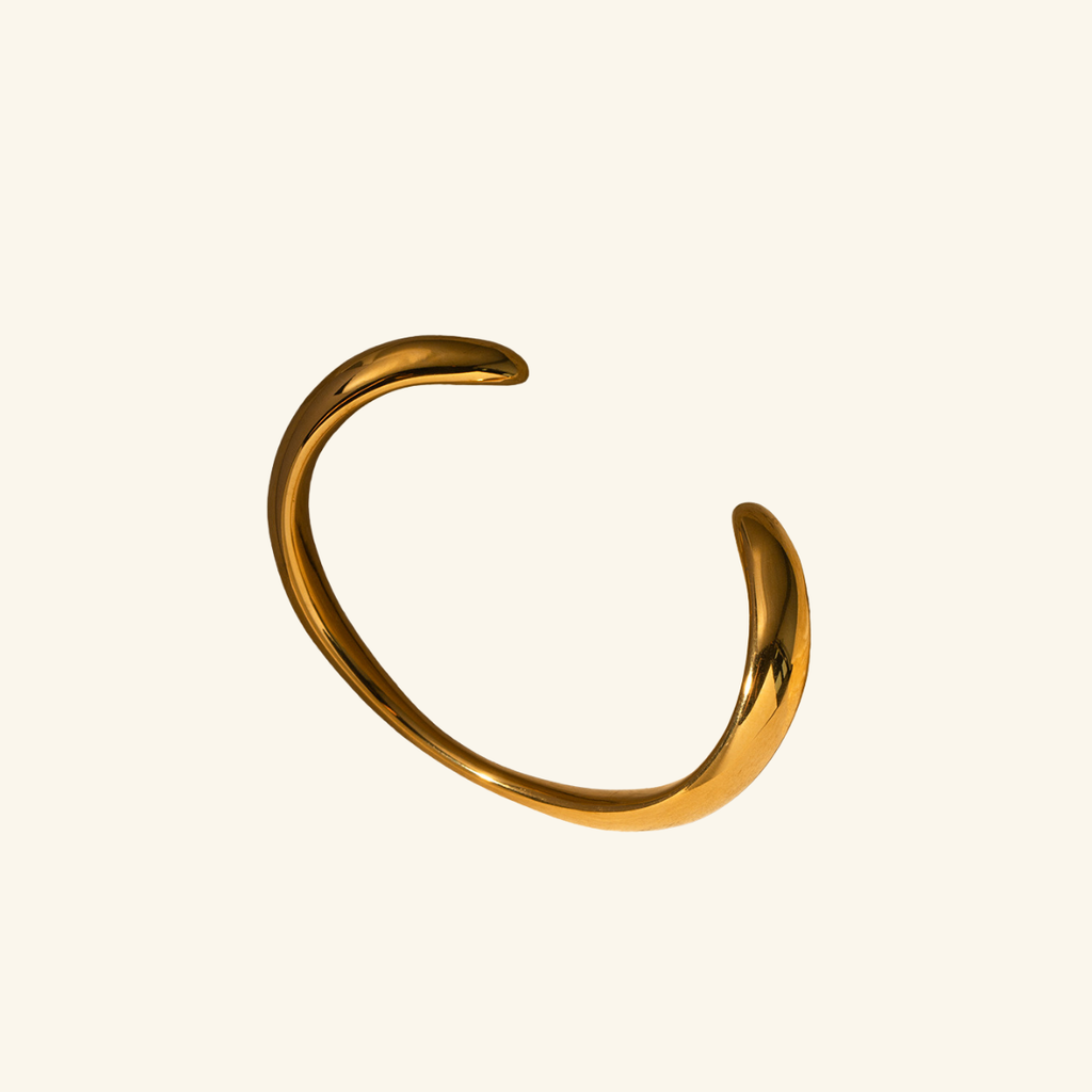 Gold bracelet on a beige background
