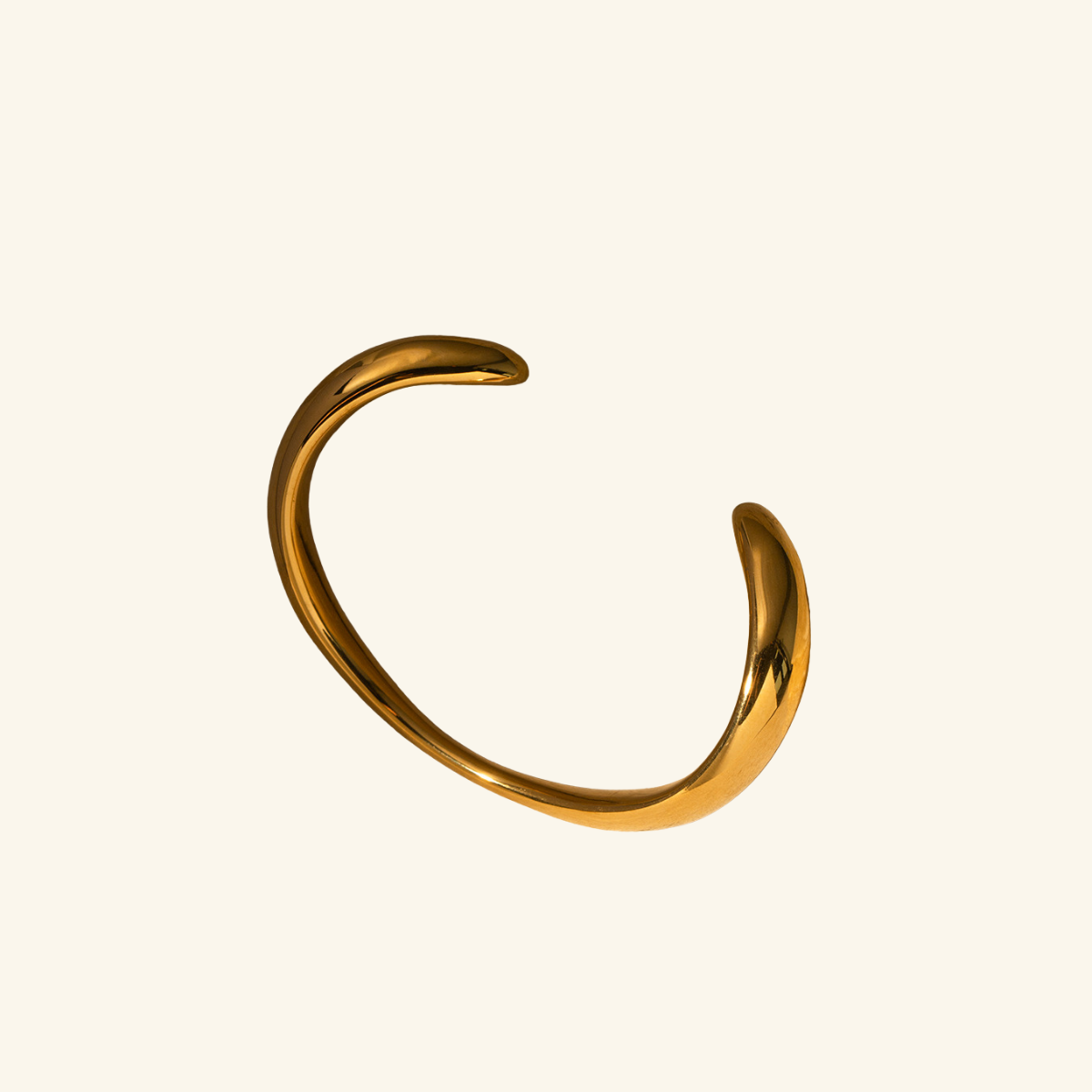 Gold bracelet on a beige background