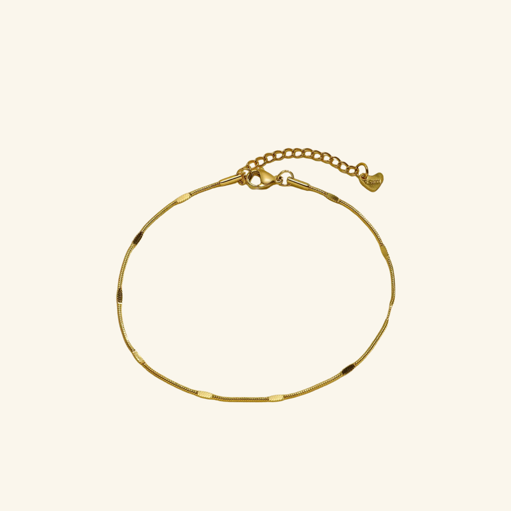 Gold bracelet on a beige background
