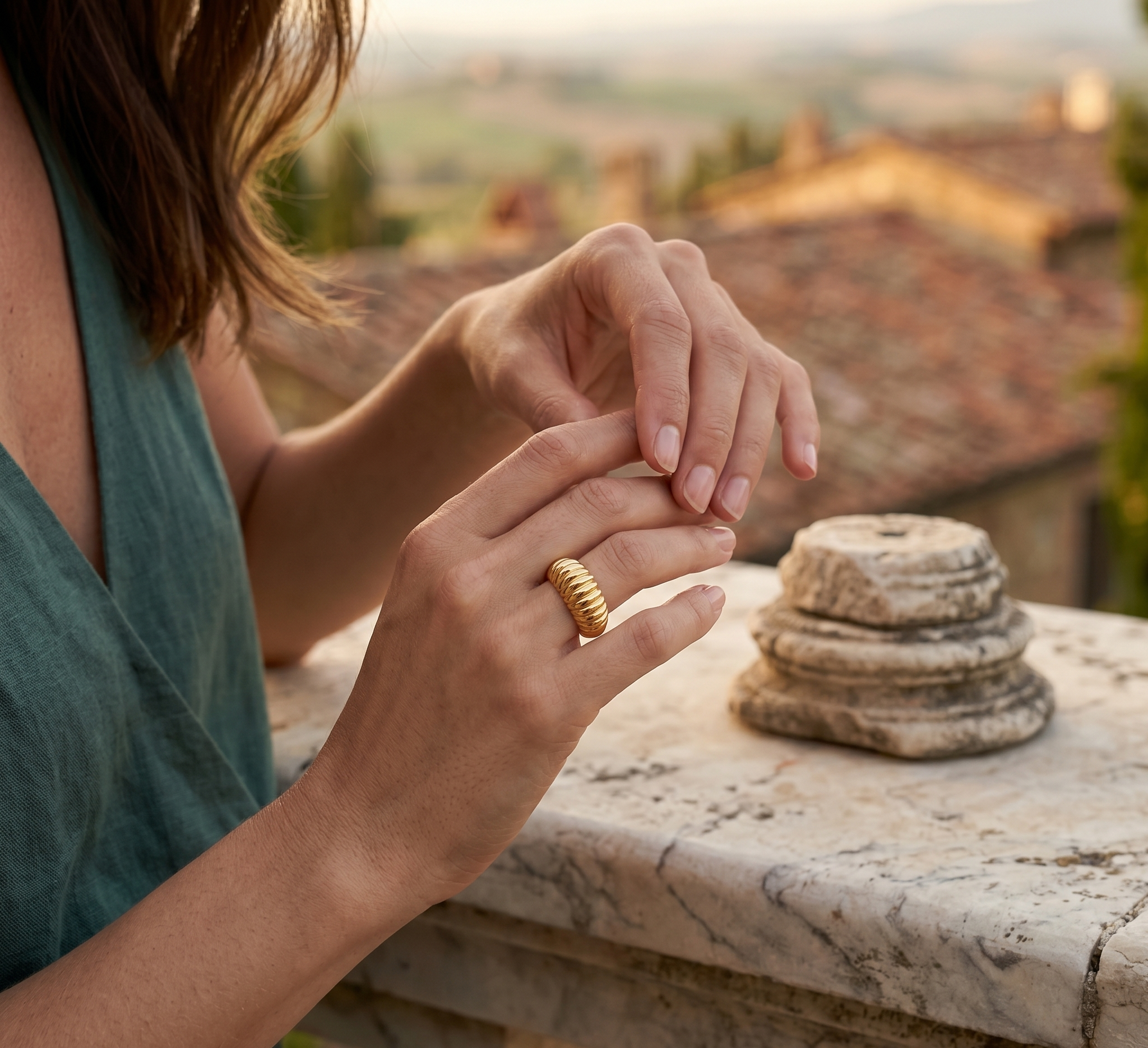 Person wearing a gold ring with a scenic background